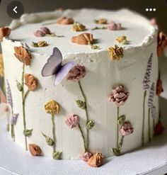 a white cake with flowers and butterflies on it