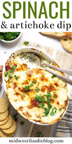 spinach and artichoke dip in a casserole dish with crackers on the side