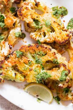 broccoli florets on a plate with lemon wedges