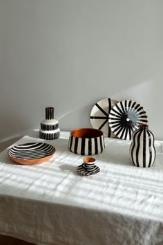 several black and white vases sitting on top of a table