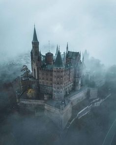 an aerial view of a castle in the fog