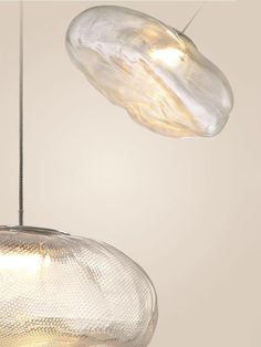 two clear glass lamps hanging from a ceiling