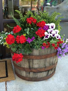 a wooden barrel filled with lots of colorful flowers