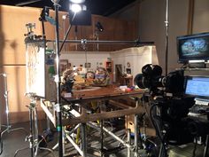 a camera set up in front of a desk with two monitors and other equipment on it