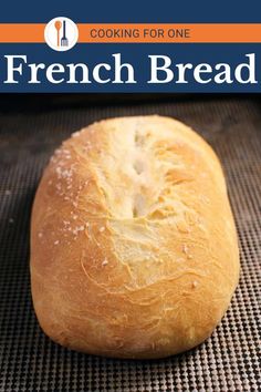 a loaf of bread sitting on top of a baking mat with the title cooking for one french bread