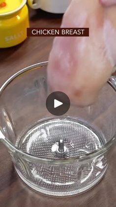 a video demonstrating how to cook chicken breast in a glass bowl on a wooden table