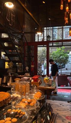 a man standing in front of a counter filled with pastries