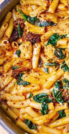 pasta with chicken, spinach and sauce in a pan