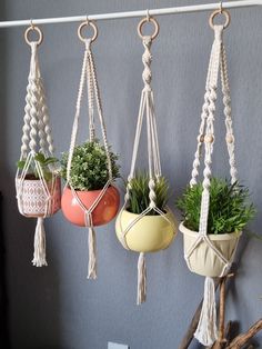 four hanging planters with plants in them