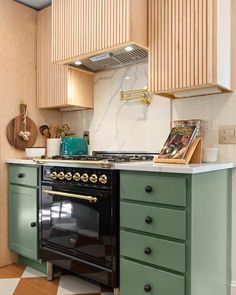 a kitchen with green cabinets and an oven