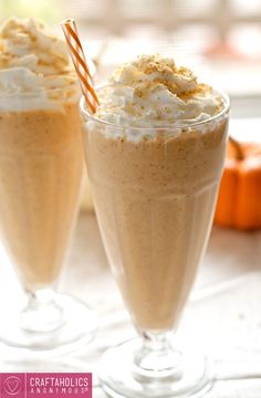 two glasses filled with whipped cream and pumpkins