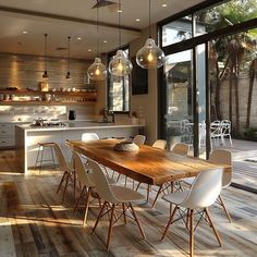 a dining room table and chairs in front of an open kitchen with sliding glass doors