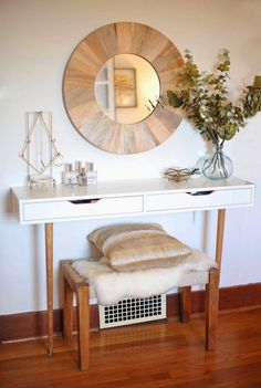 a white table with a mirror and some flowers on it