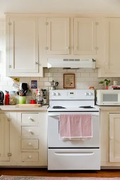 a white stove top oven sitting inside of a kitchen