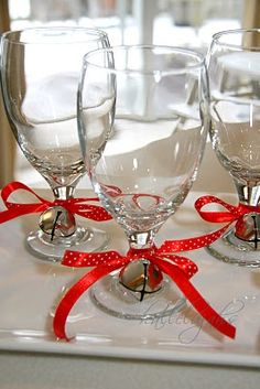 three empty wine glasses with red ribbon tied around them