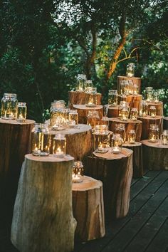 many candles are lit on wooden logs