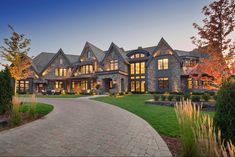 a large house with lots of windows on the front and side of it at dusk