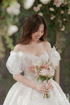 a woman in a wedding dress holding a bouquet