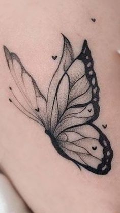 a black and white butterfly tattoo on the back of a woman's thigh,