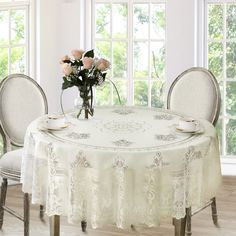 a white table cloth with roses in a vase on it