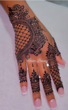 a woman's hand with henna tattoos on it