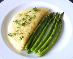 a white plate topped with fish and asparagus