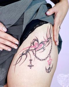 a woman's thigh with tattoos on it and a chain around her waist,