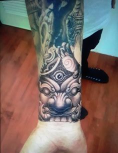 a person with a tattoo on their arm and leg is holding up his hand in front of the camera