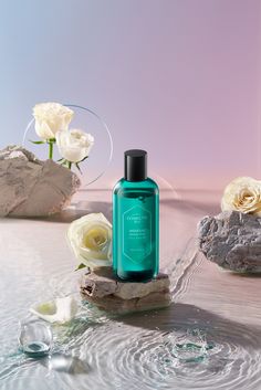 a bottle of body lotion sitting on top of a rock in water next to flowers