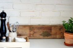 a wooden box with utensils and other kitchen items in it sitting on a counter