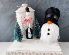 two snowmen are sitting next to each other on a white shelf with christmas decorations