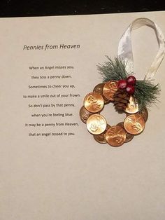 a christmas card with coins and a pine cone on the front, hanging from a white ribbon