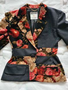 "Moschino Couture by Franco Moschino ca 1990 Blazer style jacket with slightly accentuated hips in black woolen cloth and floral velvet with a chiseled effect, collar with notch lapel, closure with one fabric-covered button (there is one spare button with the fabric tag), two front flap pockets, one chest pocket, cuffs with four fabric-covered buttons (there is one spare inside a pocket), black lining. Brand tag: early 90s black on white \"Moschino Couture !\" with golden heart and golden chain Winter Fitted Patchwork Blazer, Winter Patchwork Fitted Blazer, Black Patchwork Blazer For Spring, Spring Black Patchwork Blazer, Winter Floral Print Fitted Outerwear, Fitted Winter Outerwear With Floral Print, Chic Fitted Blazer With Floral Print, Fitted Floral Print Winter Blazer, Elegant Black Blazer With Floral Print