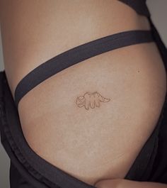 a woman's stomach with a small tattoo on the lower part of her belly