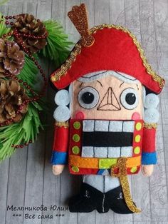 a nutcracker ornament sitting next to a pine cone