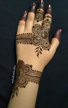 a woman's hand with henna tattoos on it