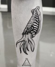 a black and white photo of an octopus tattoo on the leg