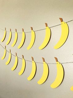 yellow paper bananas are hanging on a string