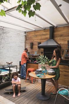 a woman sitting at a table next to a little boy in front of an oven