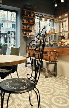 a table and some chairs in a room with food on the shelves behind it,