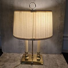 a lamp that is sitting on top of a table next to a wall with a light in it