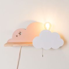 a light that is on the side of a shelf with a cloud shaped lamp next to it