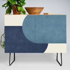 a blue and white cabinet sitting next to a potted plant on top of it