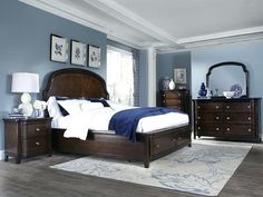 a bedroom with blue walls and wooden furniture