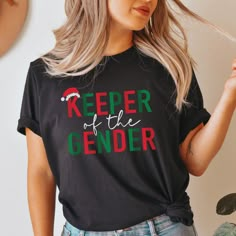 a woman wearing a t - shirt that says keeper of the gender