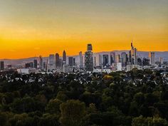 the city skyline is shown at sunset with mountains in the background