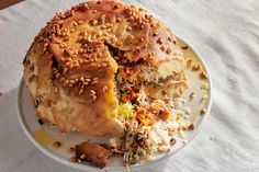 a white plate topped with a bagel covered in nuts and other toppings on top of a table