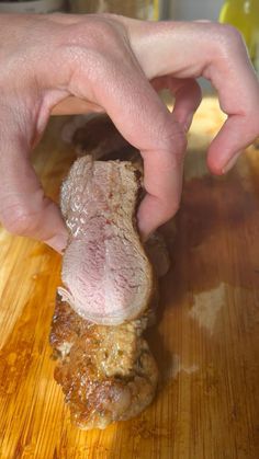 a person is cutting up some meat on a wooden table