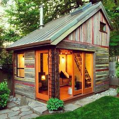 a small wooden shed with windows on the roof and doors open to let in light