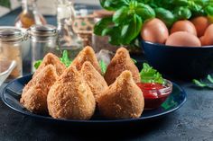 some fried food is on a plate next to eggs and ketchup sauces